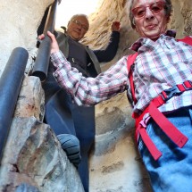 Tommy and Jutta descending a narrow spiral stair inside the castle